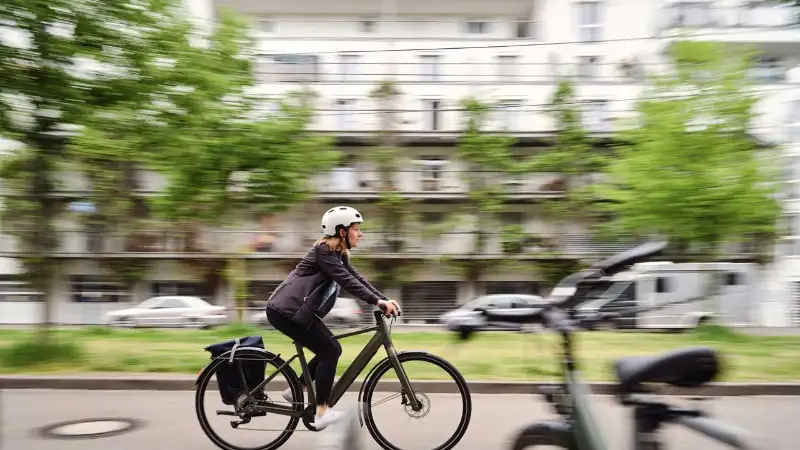 JobRadlerin fährt am Fahrradständer vorbei