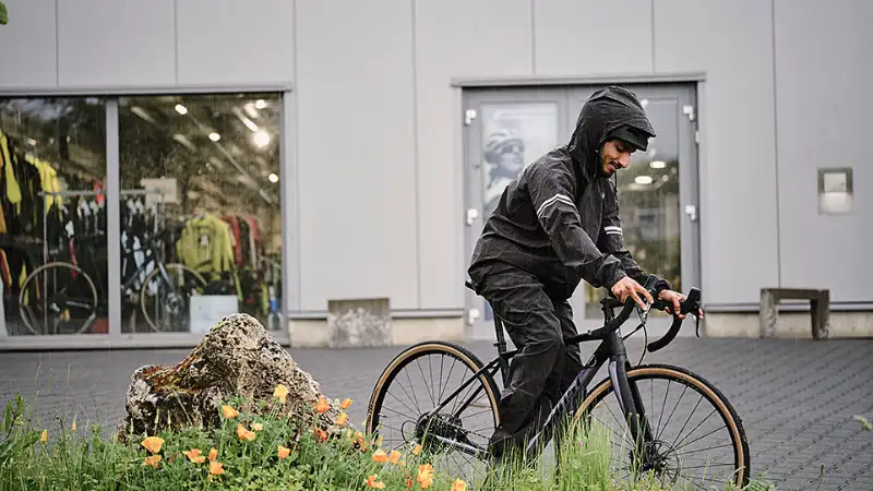 JobRadler im Regen mit Grünstreifen auf Vorplatz