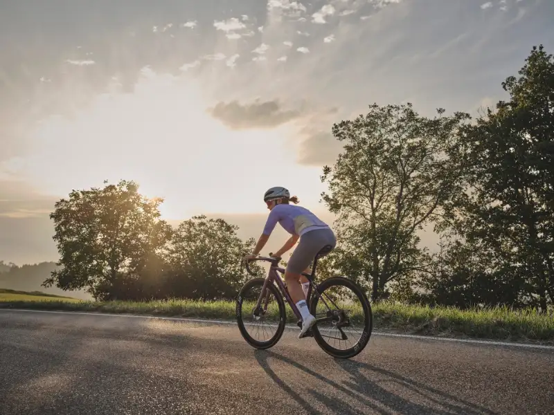 Rennradlerin fährt in den Sonnenuntergang