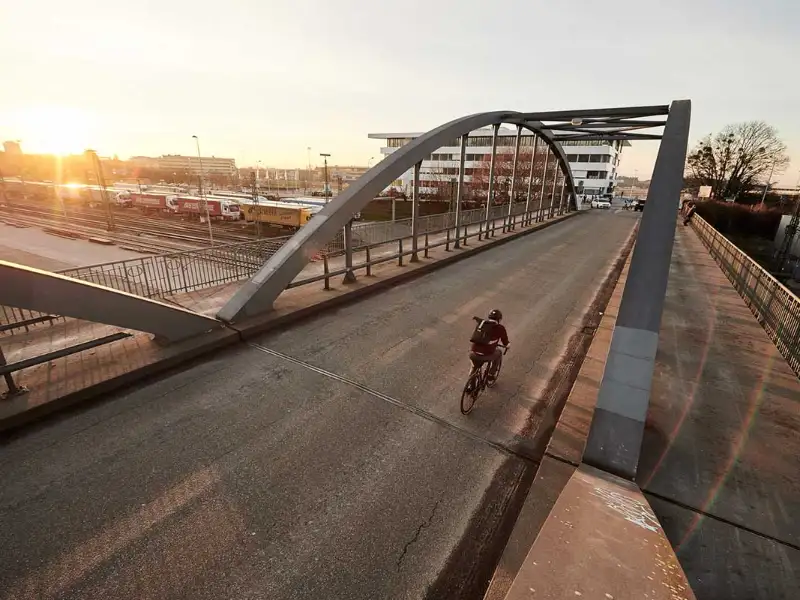 Radler auf der Blauen Brücke in Freiburg im Sonnenuntergang