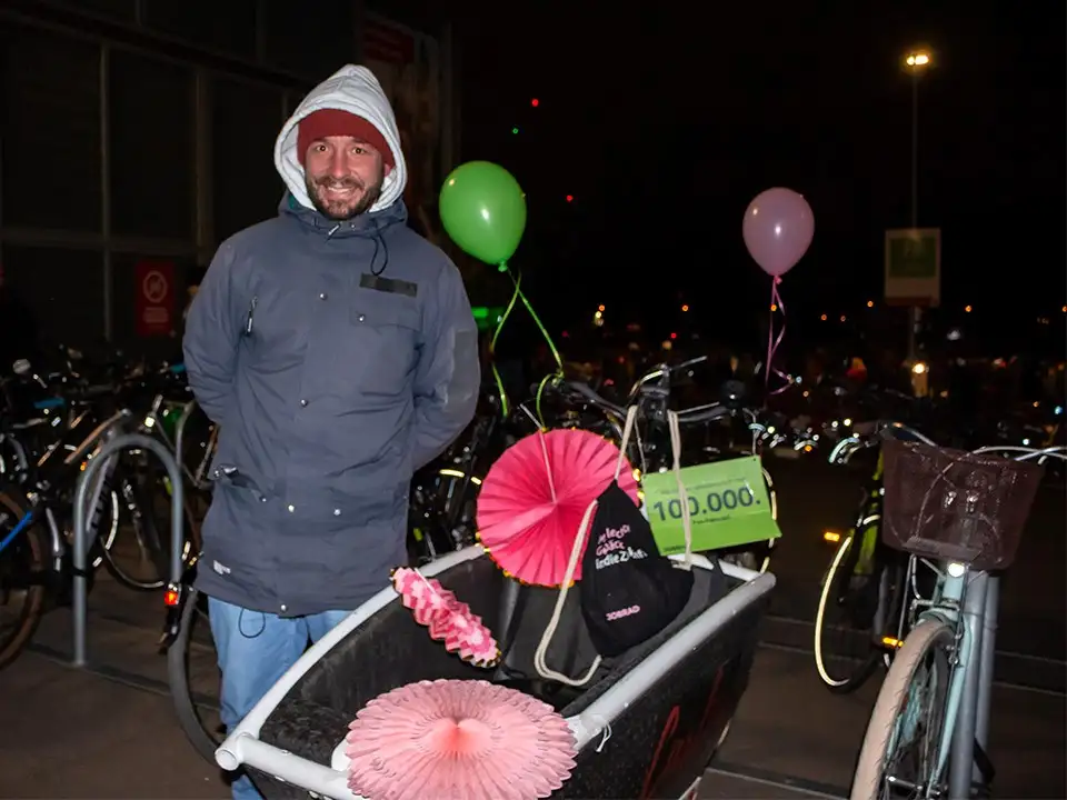 Michael, der 100.000ste Fahrradfan steht stolz neben seinem geschmückten Lastenrad