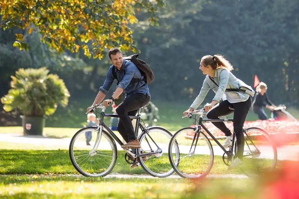 Zwei Radfahrer von der Seite im Park Herbst