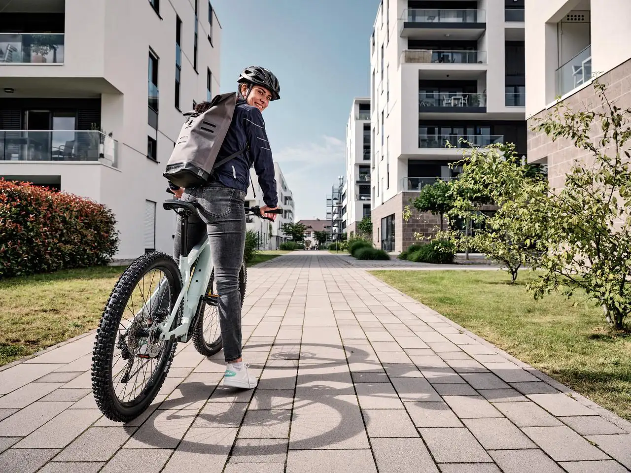 JobRadlerin mit Mountainbike in einer Häuserschlucht