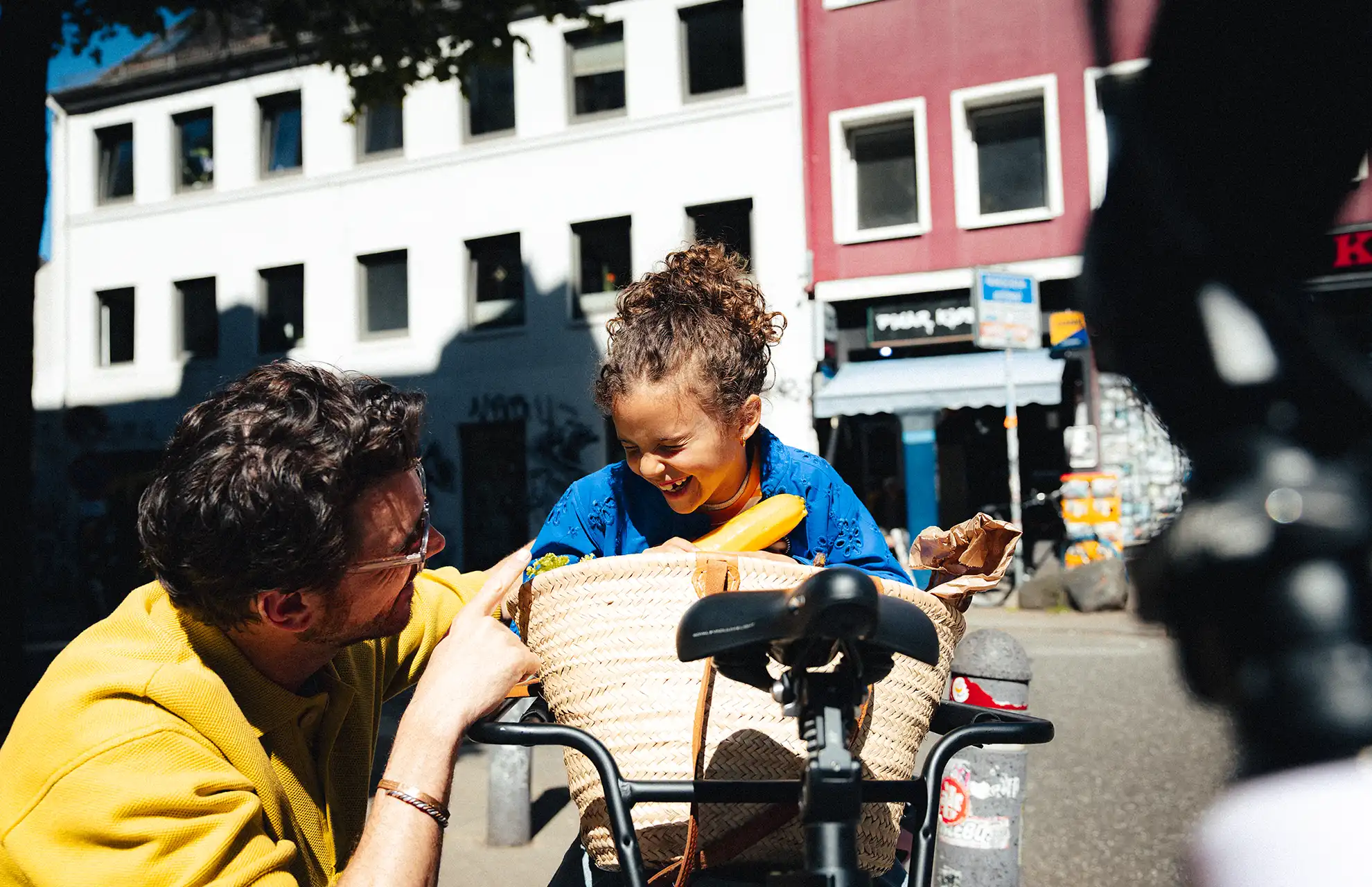Vater-mit-Tochter-und-vollgepacktem-Lastenrad